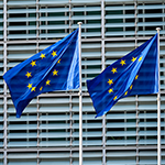 Flagi Unii Europejskiej przed budynkiem Komisji Europejskiej