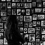 dziewczyna  na tle ściany ze starymi fotografiami