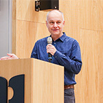 Prof. dr hab. Tomasz Szemberg przy mównicy z mikrofonem przy mównicy