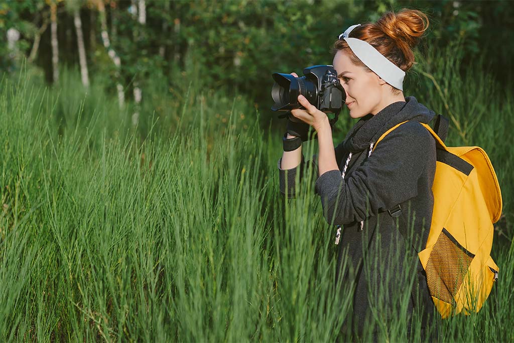 studentka z aparatem fotograficznym wśród zieleni