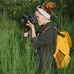 studentka z aparatem fotograficznym wśród zieleni