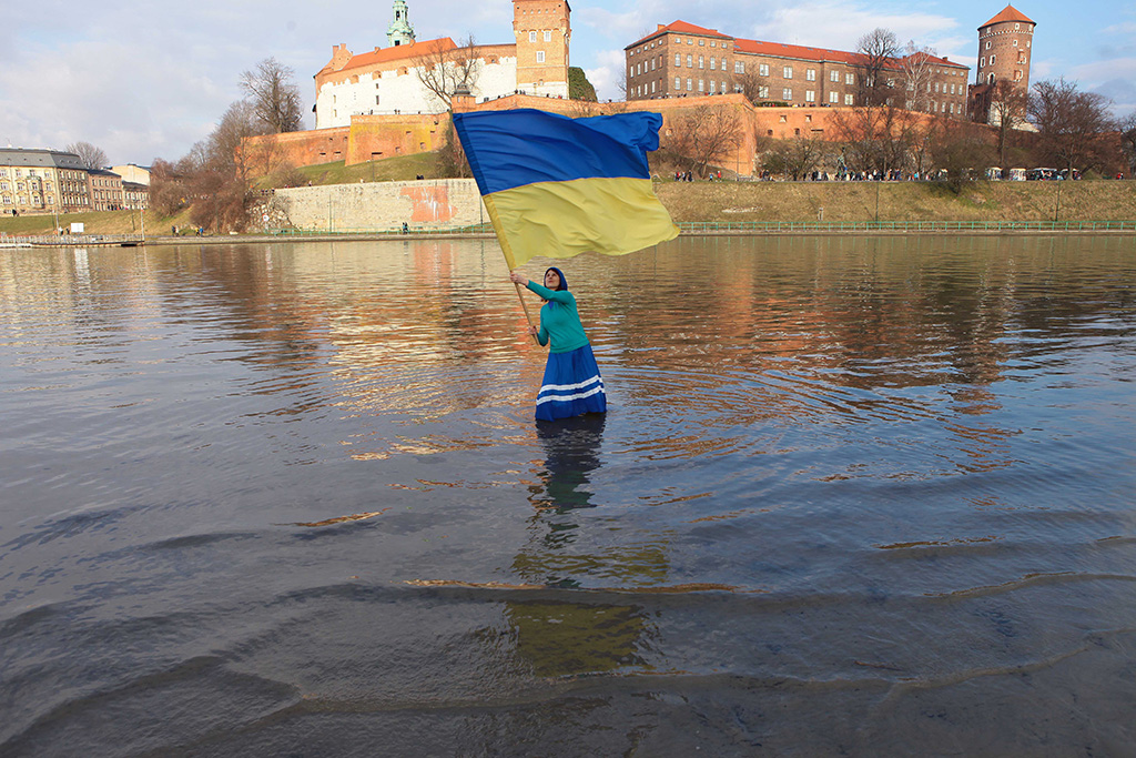 Cecylia Malik w rzece Wiśle z ukraińską flagą w dłoniach