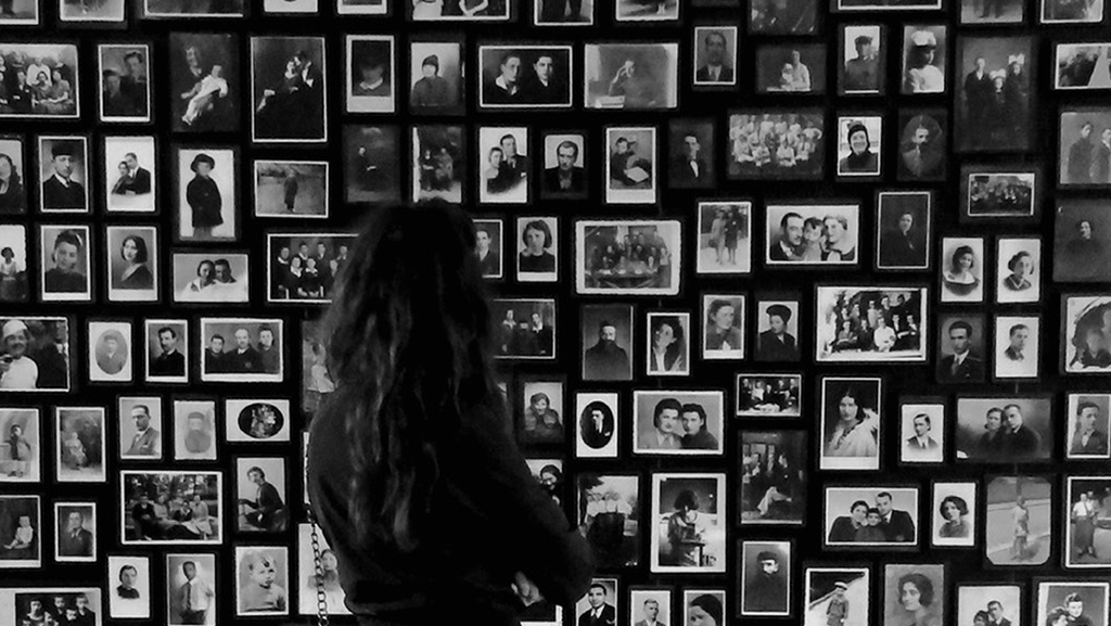dziewczyna  na tle ściany ze starymi fotografiami