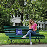 studentka siedząca na ławce przed Uniwersytetem Pedagogicznym