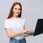 rudowłosa uśmiechnięta dziewczyna trzymająca w rękach laptopa