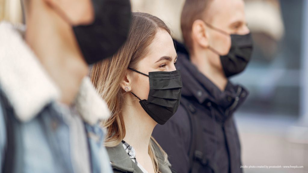 people-in-a-masks-stands-on-the-street-scaled